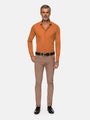 Full-body view of model wearing slim-fit orange shirt with beige trousers and black shoes – Wam Denim.