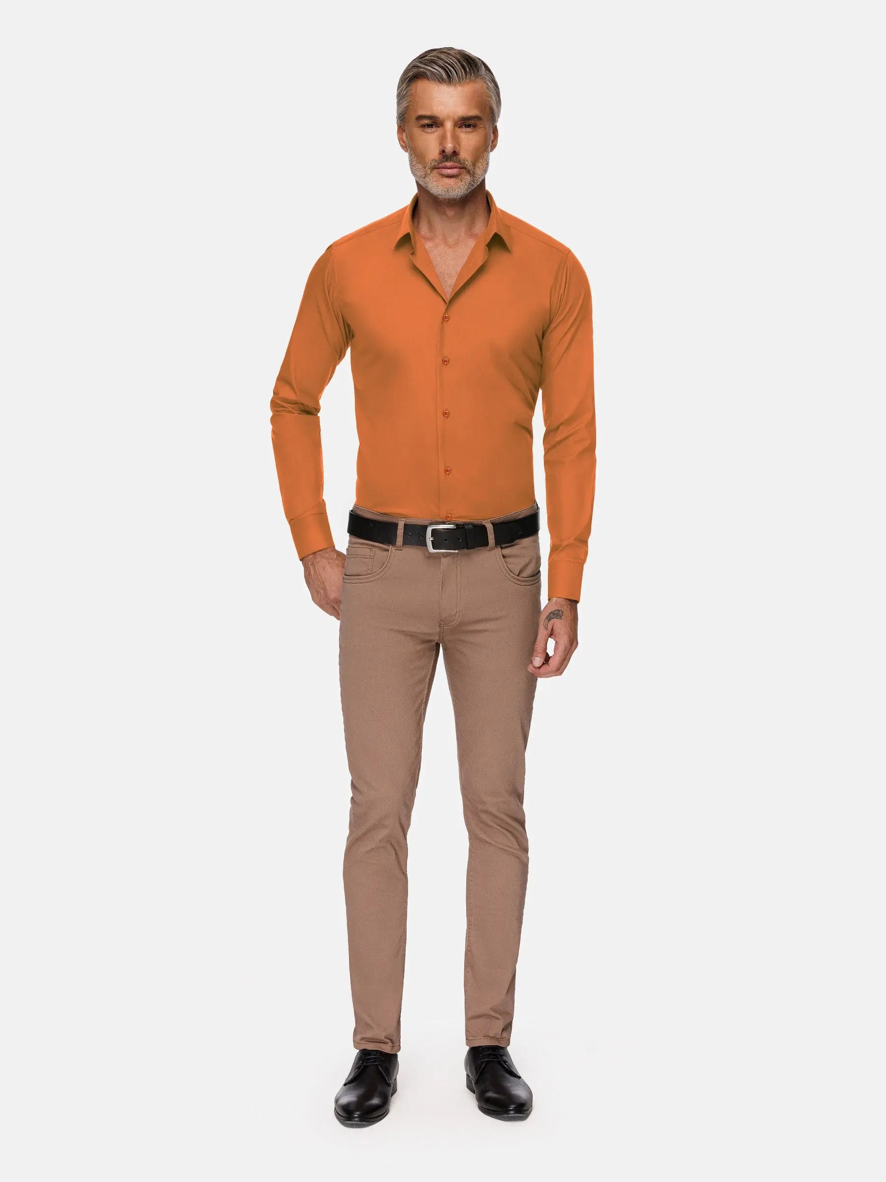Full-body view of model wearing slim-fit orange shirt with beige trousers and black shoes – Wam Denim.