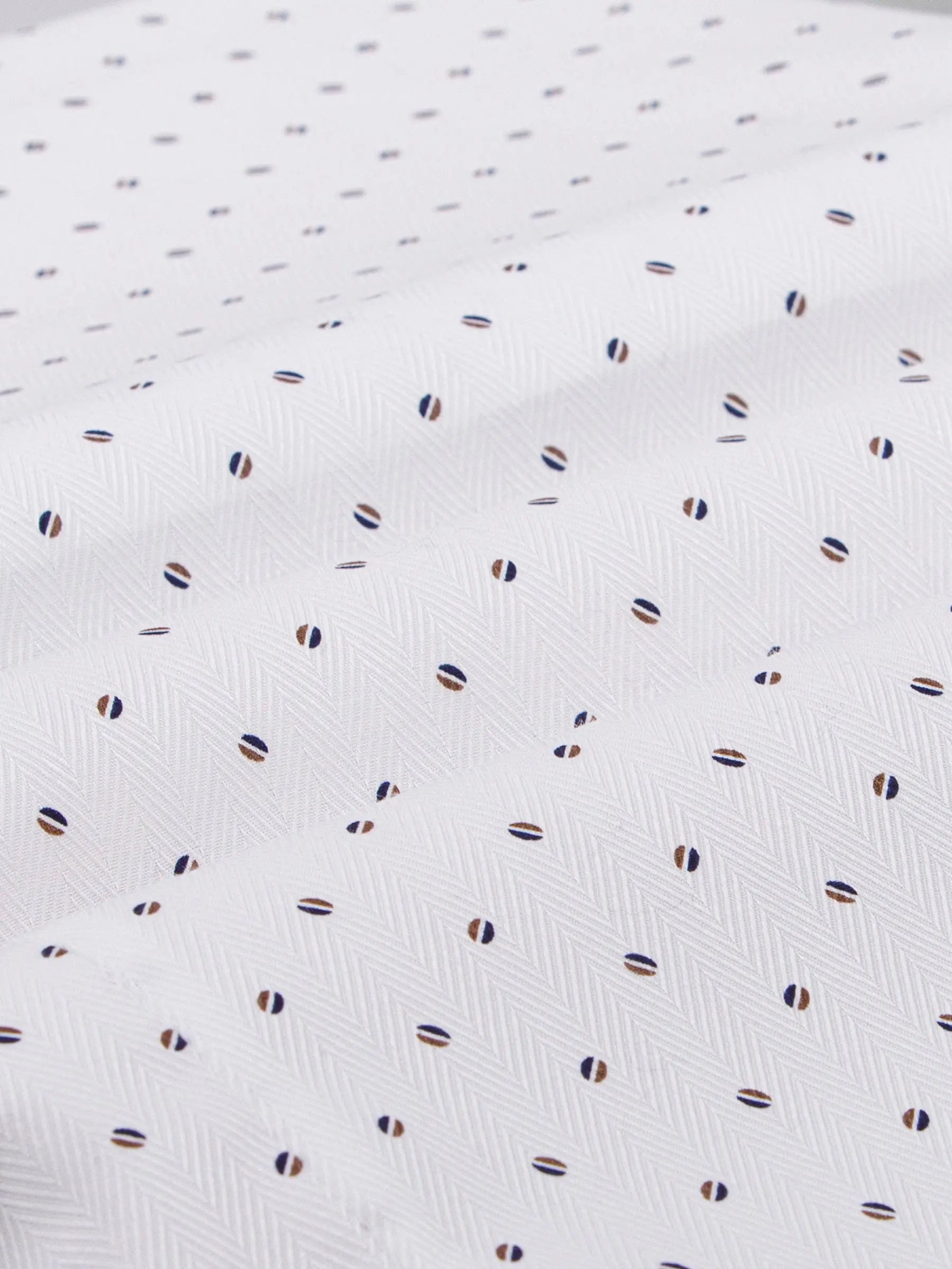 Close-up of white shirt fabric with navy and brown mini-dot pattern in herringbone texture – Wam Denim.