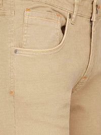 Close-up of beige denim pants with orange stitching and pocket. – Wam Denim.