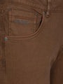 Close-up of brown jeans hem with rugged denim texture. – Wam Denim.