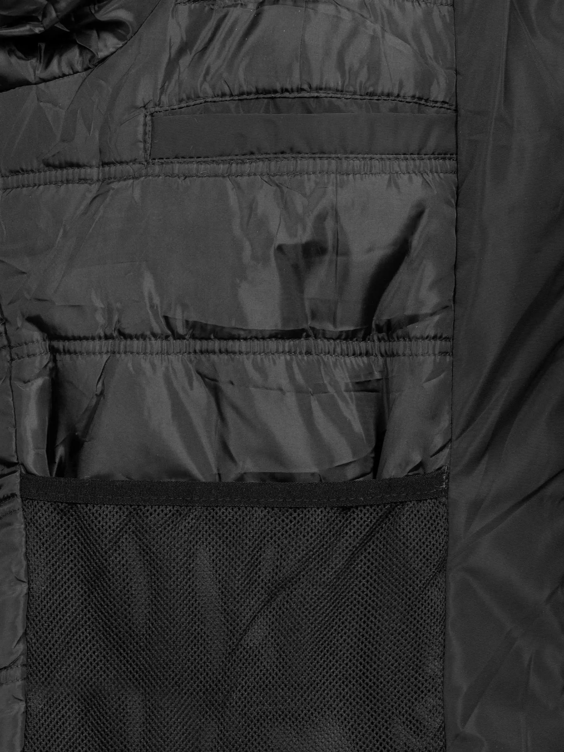 
Close-up of the mesh and zipped inner pockets on the black jacket – Wam Denim.