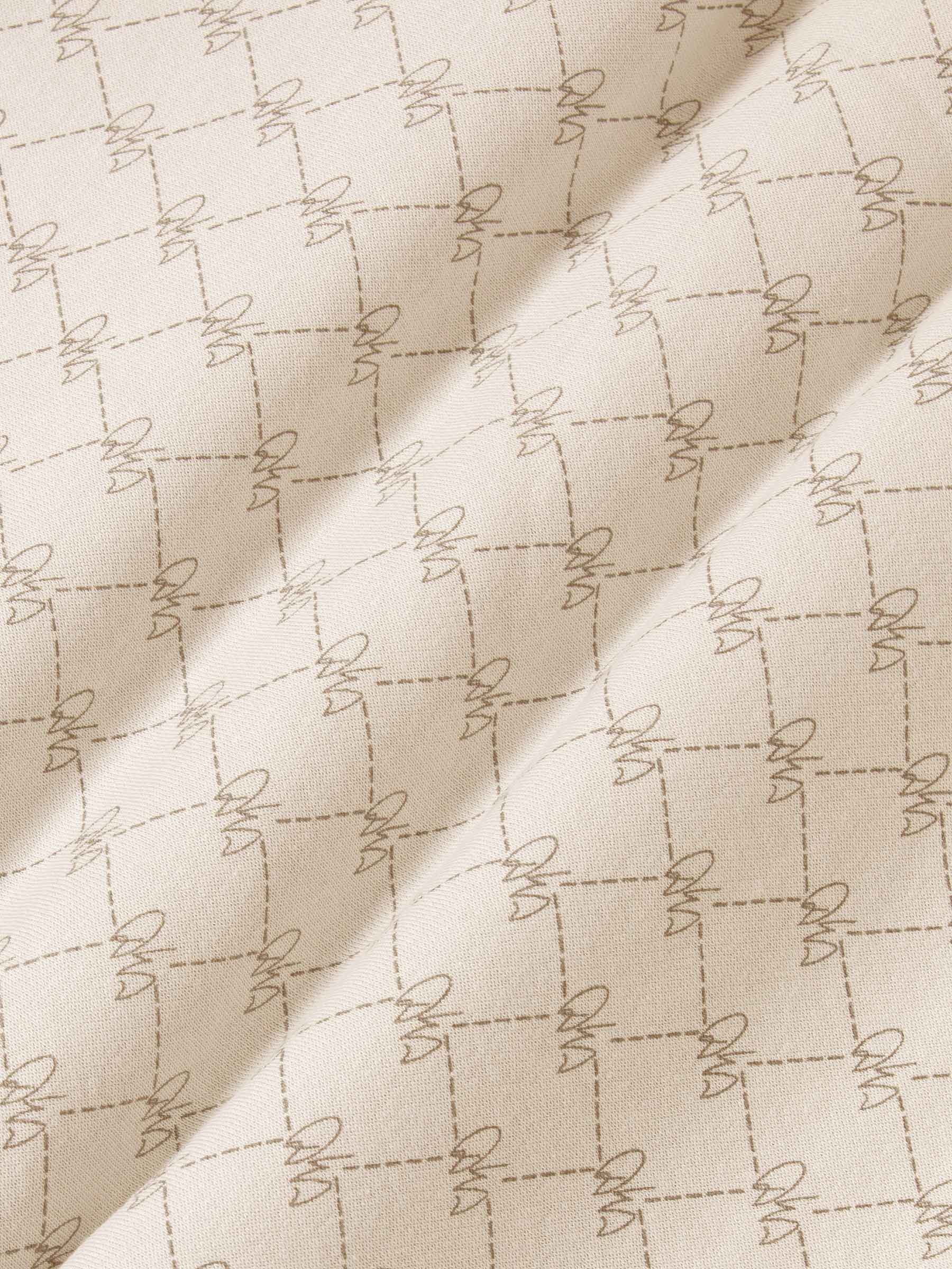Close-up of beige fabric with geometric stitched pattern for hoodie texture – Wam Denim.