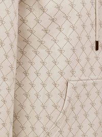 Close-up of beige hoodie pocket with stitched geometric pattern and fine detailing – Wam Denim.