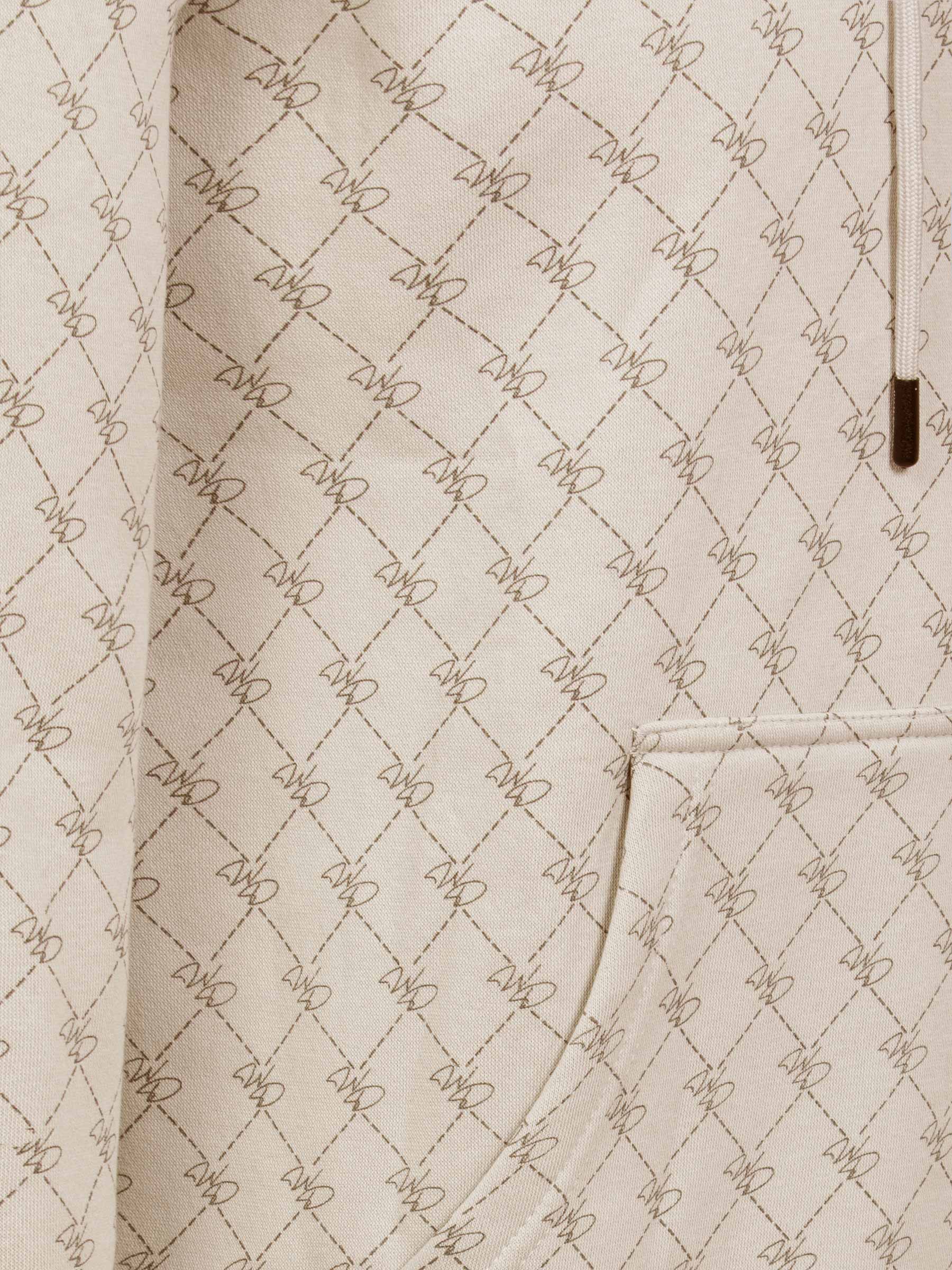 Close-up of beige hoodie pocket with stitched geometric pattern and fine detailing – Wam Denim.