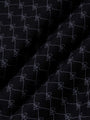 Close-up of black fabric with stitched geometric logo pattern and soft texture – Wam Denim.