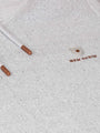 Close-up of a textured fabric surface with a small logo and two cylindrical objects.