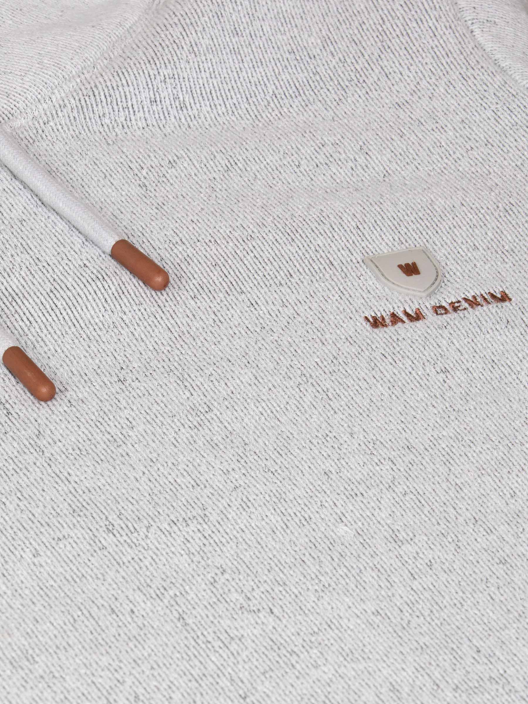Close-up of a textured fabric surface with a small logo and two cylindrical objects.