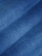 Close-up texture of light blue denim fabric showing fine weave and smooth finish – Wam Denim.
