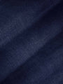 Close-up of dark navy denim fabric texture showing smooth weave and slight fade – Wam Denim.