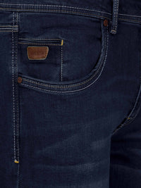 Front pocket close-up of dark navy jeans with leather Wam Denim label and contrast stitching – Wam Denim.