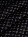 Close-up of black fabric with beige geometric pattern showing soft textured weave – Wam Denim.