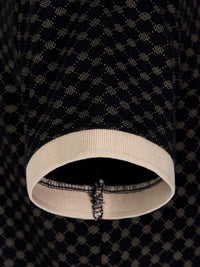 Close-up of polo sleeve showing beige ribbed cuff and geometric black fabric – Wam Denim.