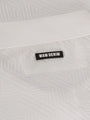 Close-up of the Wam Denim logo on the white polo shirt collar – Wam Denim.