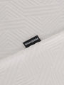 Close-up of the Wam Denim label on the textured white polo – Wam Denim.