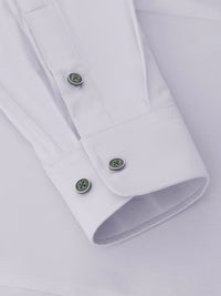 Close-up of the cuff on a white men's dress shirt with green buttons – Wam Denim.