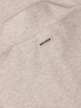 Close-up of beige fabric with a 'Wam Denim' label.