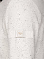 Speckled Off White sweater with a brand label on a matching background