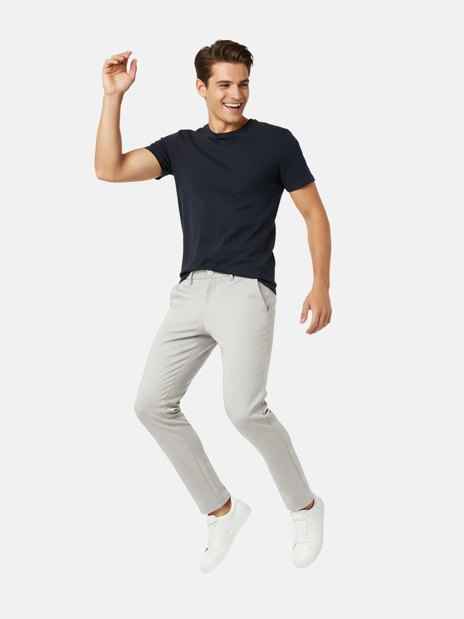 Full-body view of a man wearing light grey slim-fit pantalon styled with a navy t-shirt.