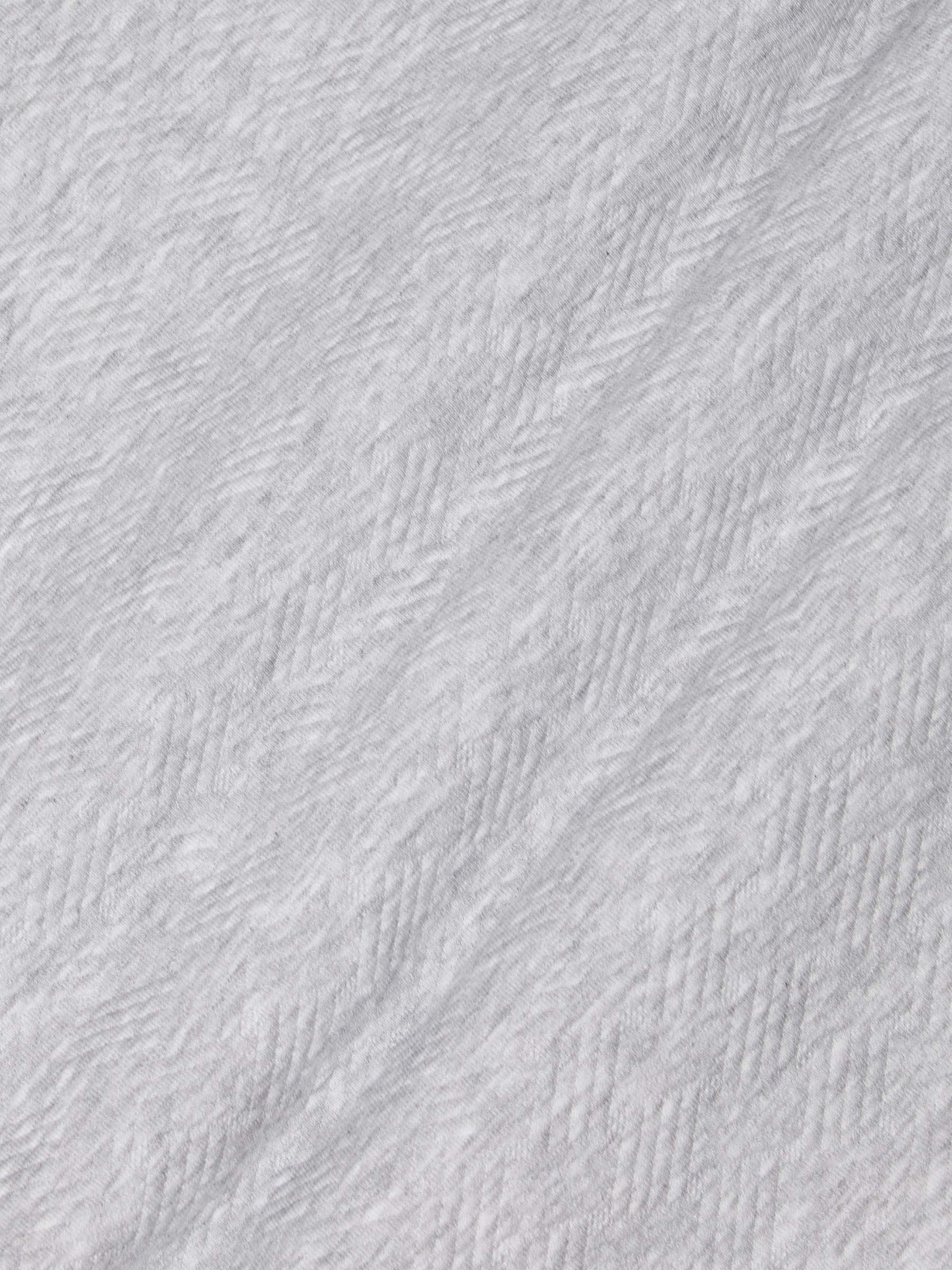 Close-up of light grey textured fabric showcasing soft herringbone knit pattern – Wam Denim.