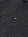 Close-up of ribbed Anthracite fabric featuring a small woven Wam Denim logo tag – Wam Denim.