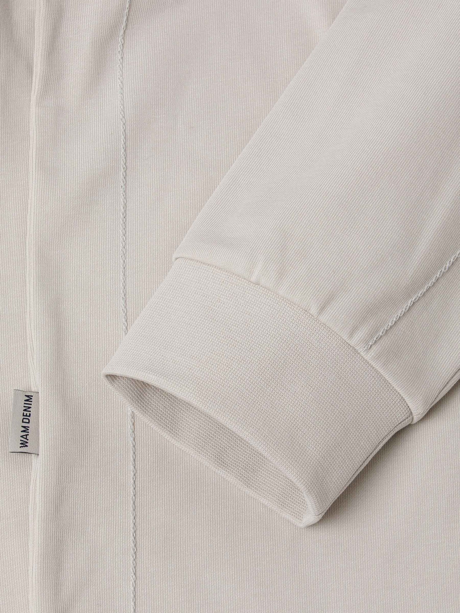 Close-up of The Fervor Light Beige Sweater sleeve cuff and side label stitching detail – Wam Denim.