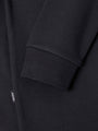 Close-up of The Zeal Black Sweater sleeve cuff showing ribbed finish and woven label – Wam Denim.