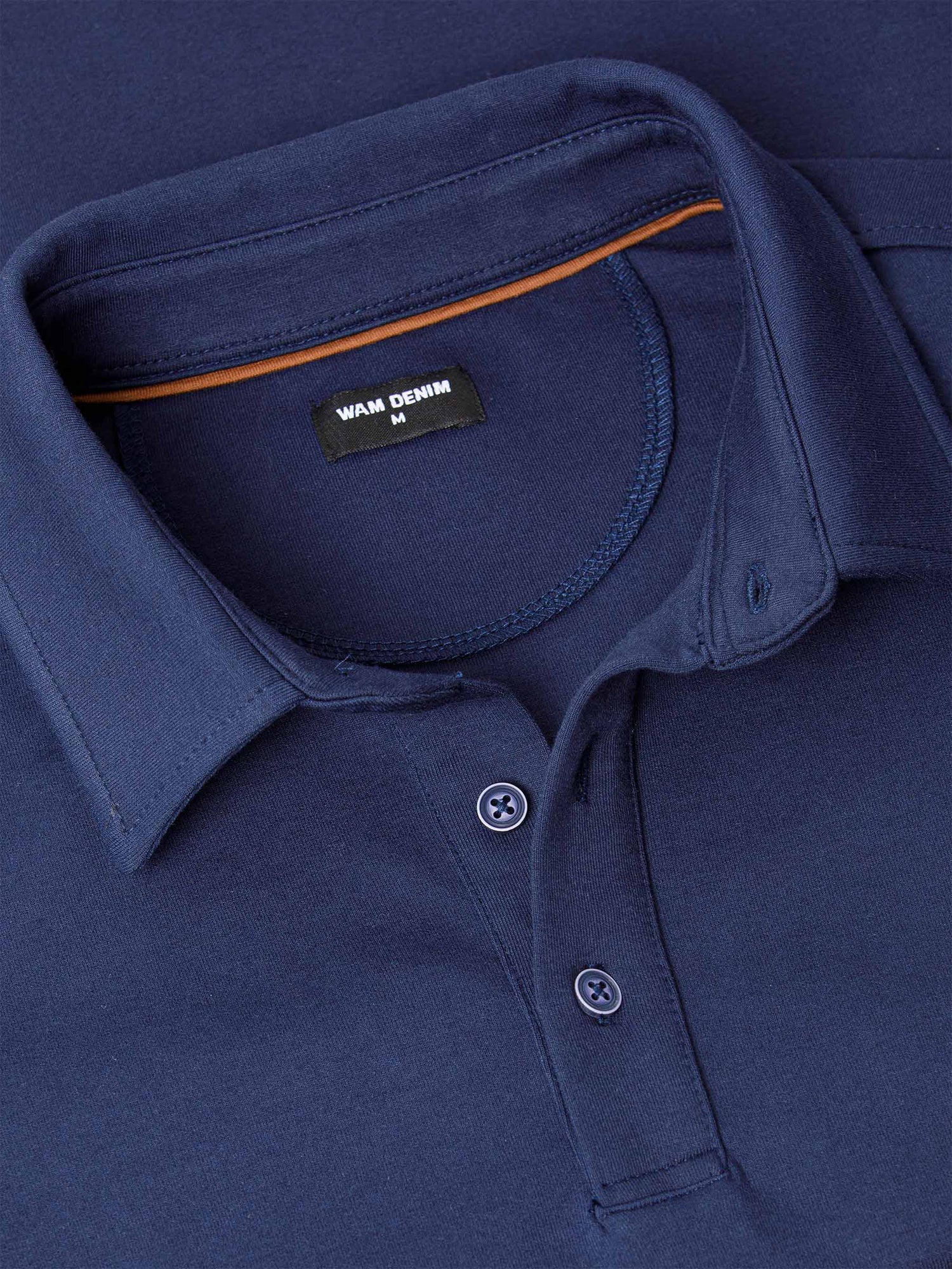 Close-up of a Navy Sweater with a brand label on the collar.