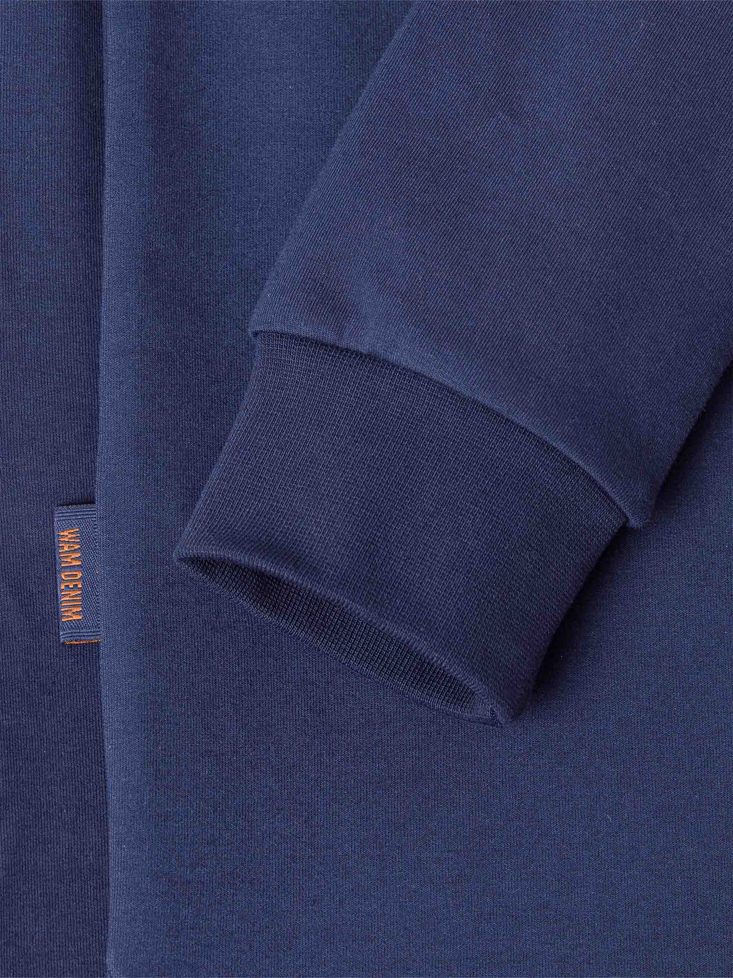 Close-up of a Navy Sweater with a brand label on a matching background