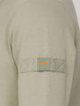 Close-up of a Light Green Sweater with a patch on the sleeve.