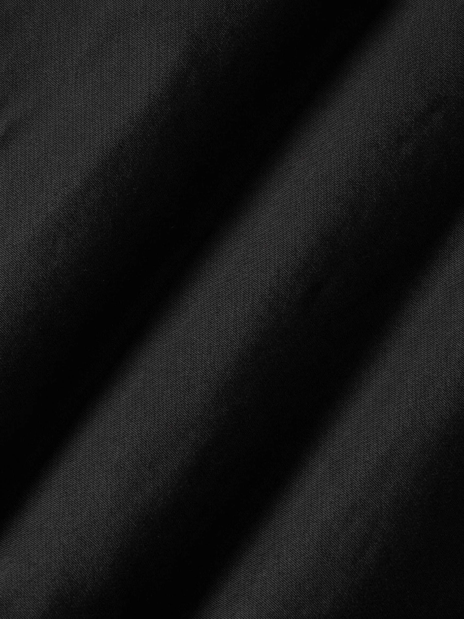 Close-up of black denim fabric showing smooth texture and fine weave detail.
