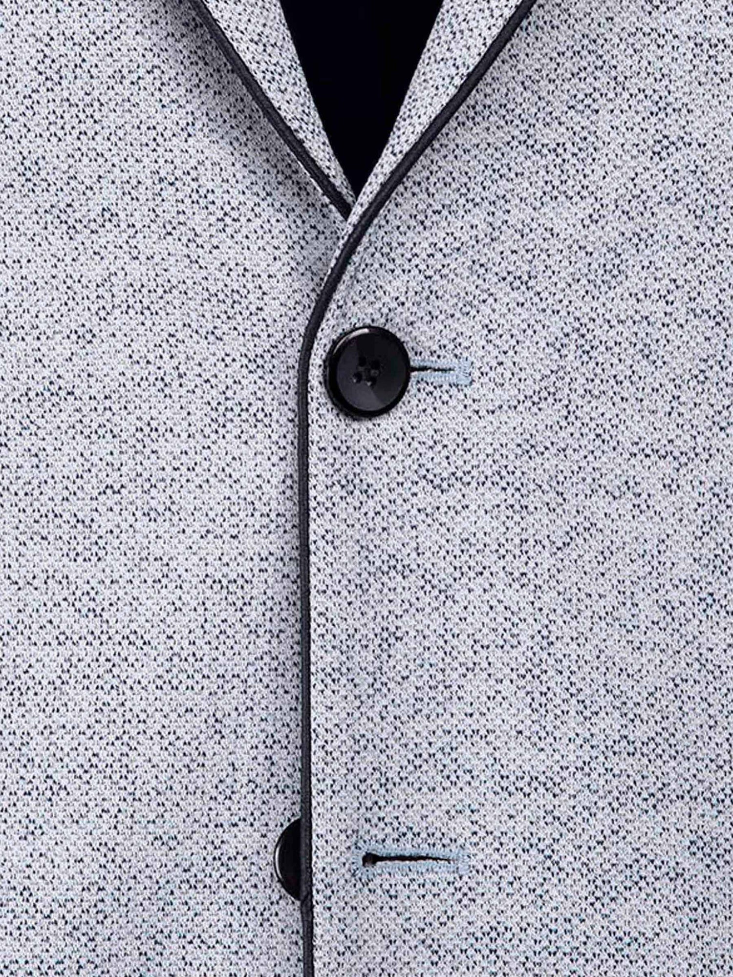 Close-up of the white-navy textured blazer fabric with dark buttons and clean stitching.
