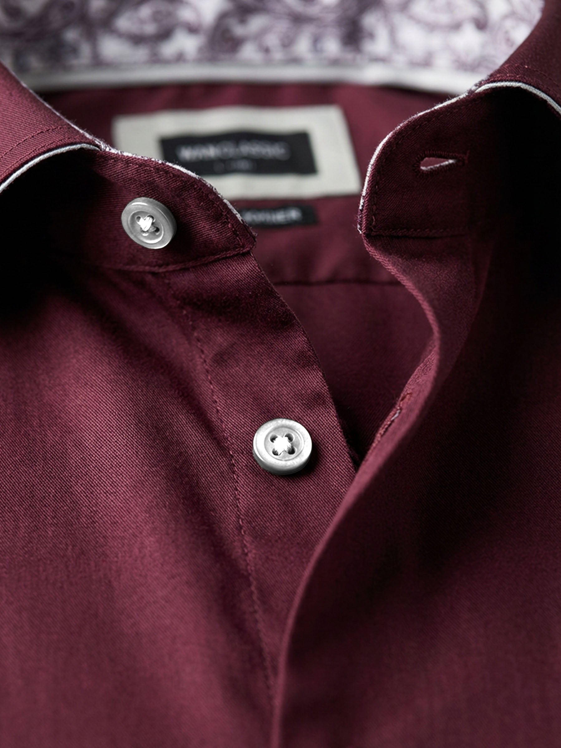 Close-up of dark red men’s shirt collar with premium buttons and smooth fabric