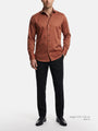 Model wearing light brown men’s dress shirt styled with black trousers and formal shoes