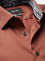 Close-up of light brown men’s shirt collar with patterned lining and premium buttons