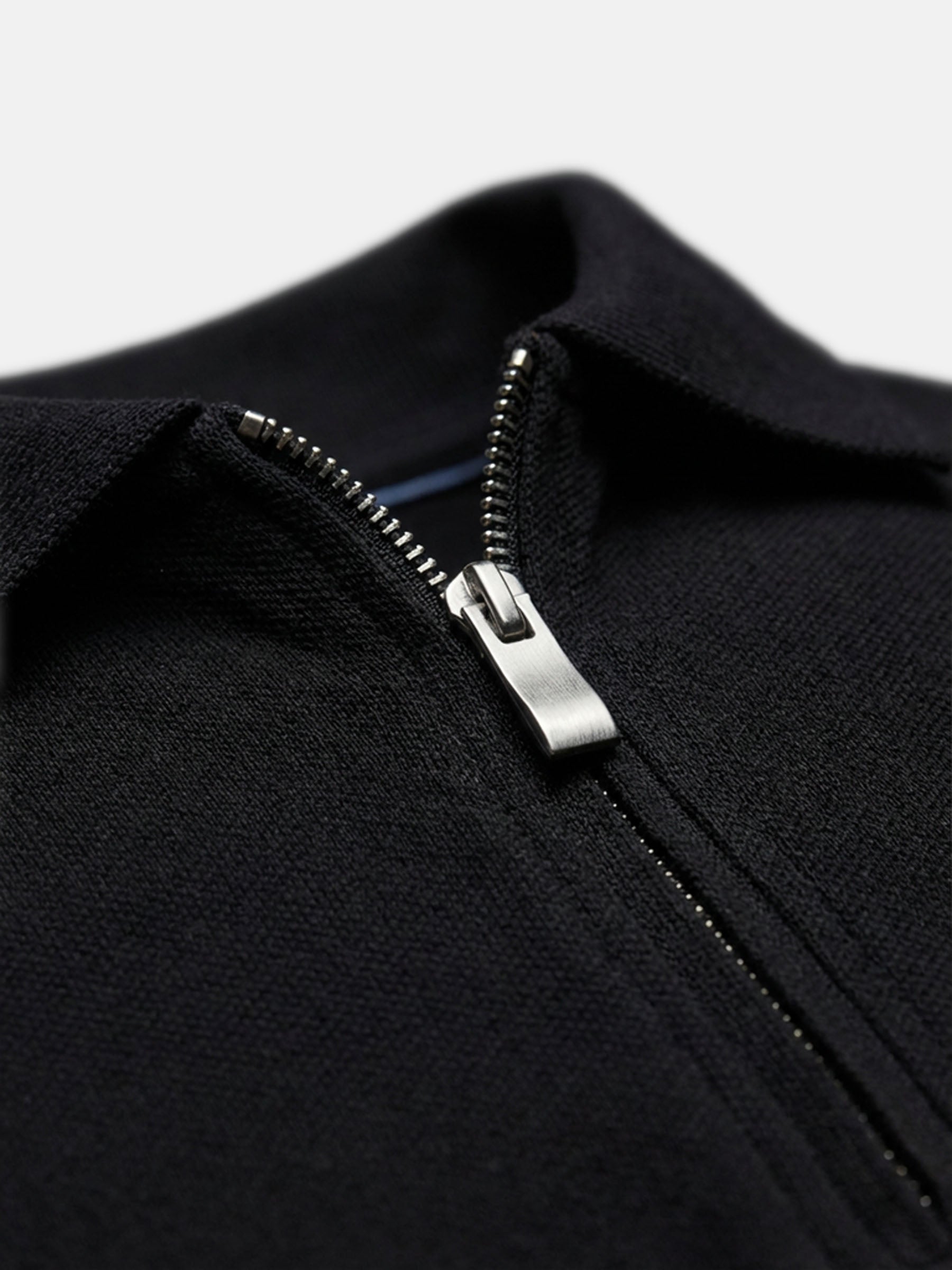 Close-up of black zip polo collar, textured cotton fabric detail for men