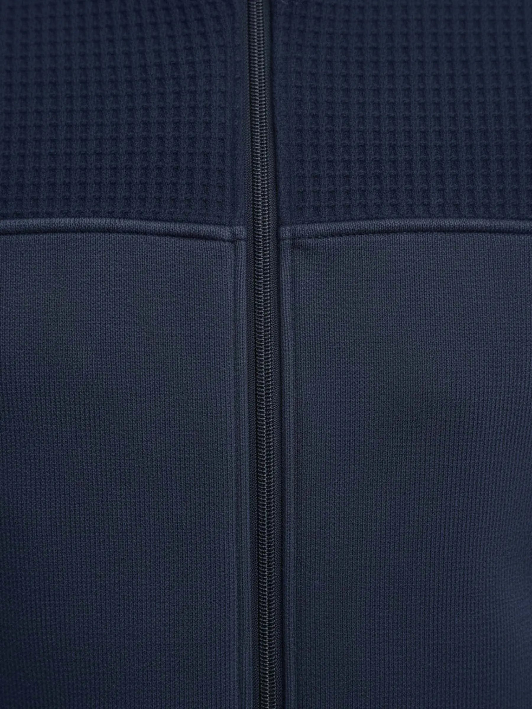 Close-up of Light Indigo jacket fabric showing textured upper panel and central zipper.