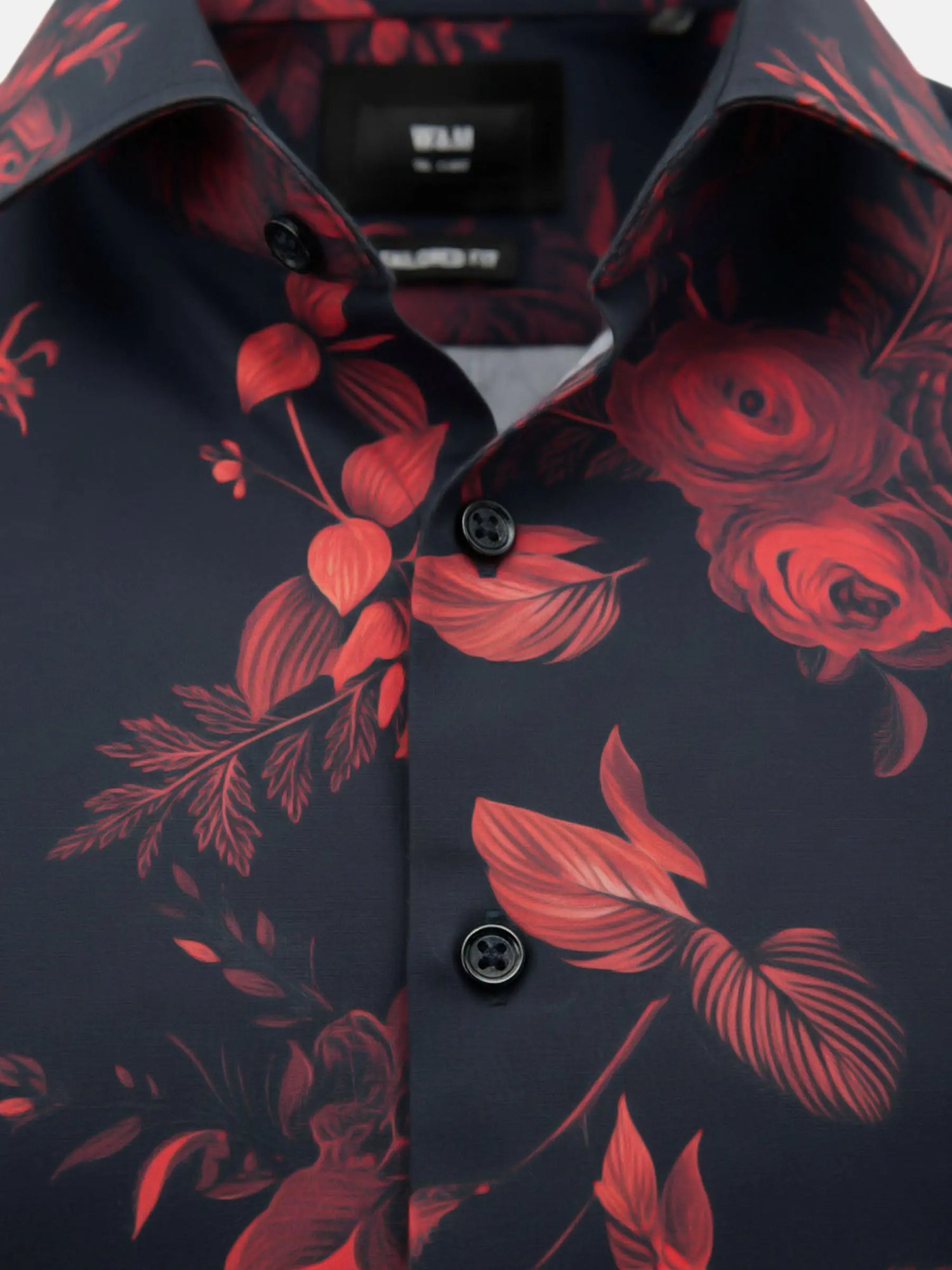 Close-up fabric detail of black shirt with vibrant red floral print pattern.