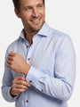 Close-up of light blue men’s shirt with contrast buttons and patterned inner collar