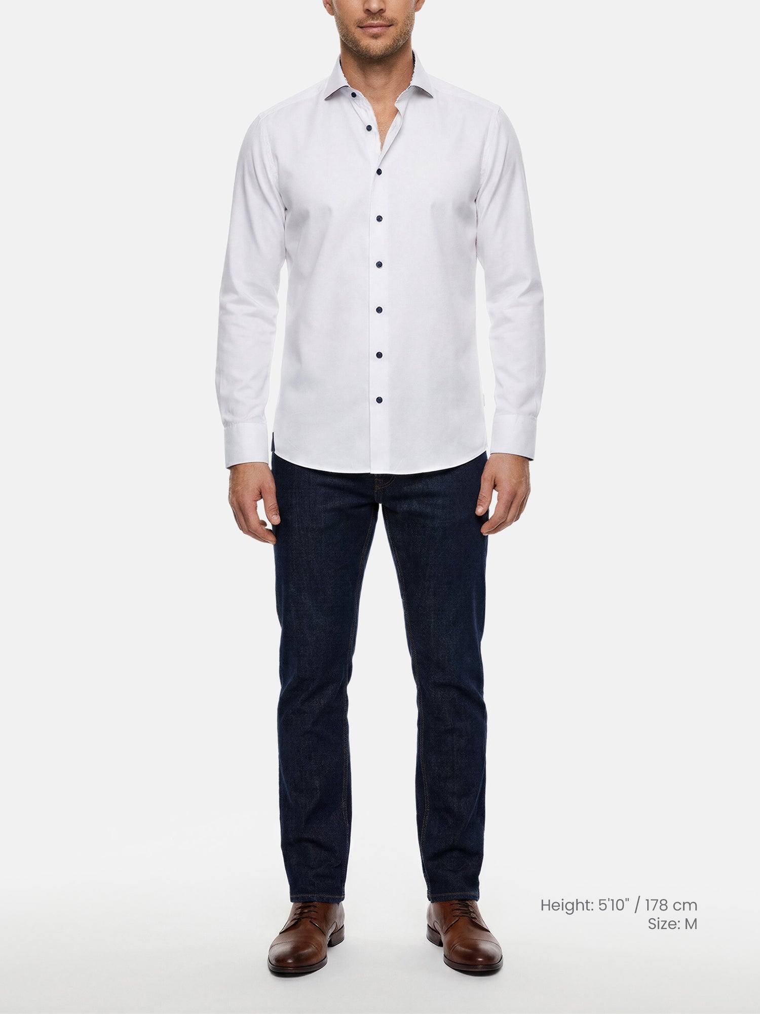 Model wearing white slim fit men’s dress shirt with dark buttons and jeans