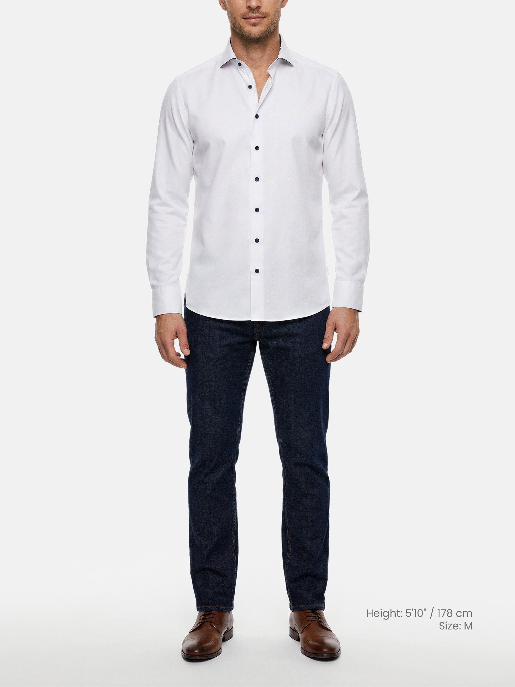 Model wearing white slim fit men’s dress shirt with dark buttons and jeans