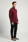 Side view of a male model wearing the Wam Denim Lux dark-red mock-neck sweater