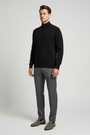 Male model wearing the Sharp black quarter-zip sweater in a three-quarter view