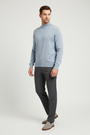 Male model wearing the Lux light-blue mock-neck sweater in a three-quarter view