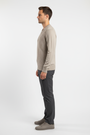 Side view of a male model wearing the Wam Denim Forge beige V-neck sweater
