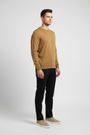 Side view of a male model wearing a dark-yellow fine-knit crew-neck sweater