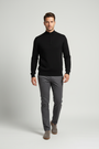Male model in a walking pose wearing the Wam Denim Halron black quarter-zip knit sweater