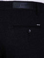 Close-up of dark navy chino trousers showing back pocket, button detail, and Wam Denim label.