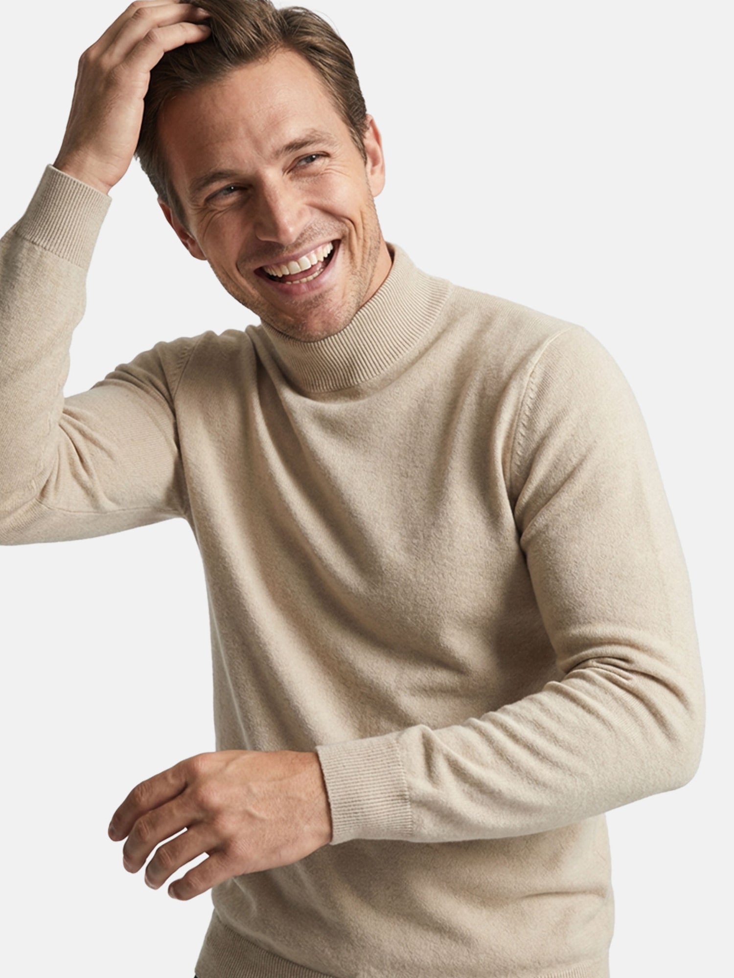 Smiling man wearing a beige mock-neck pullover in a close-up lifestyle shot.