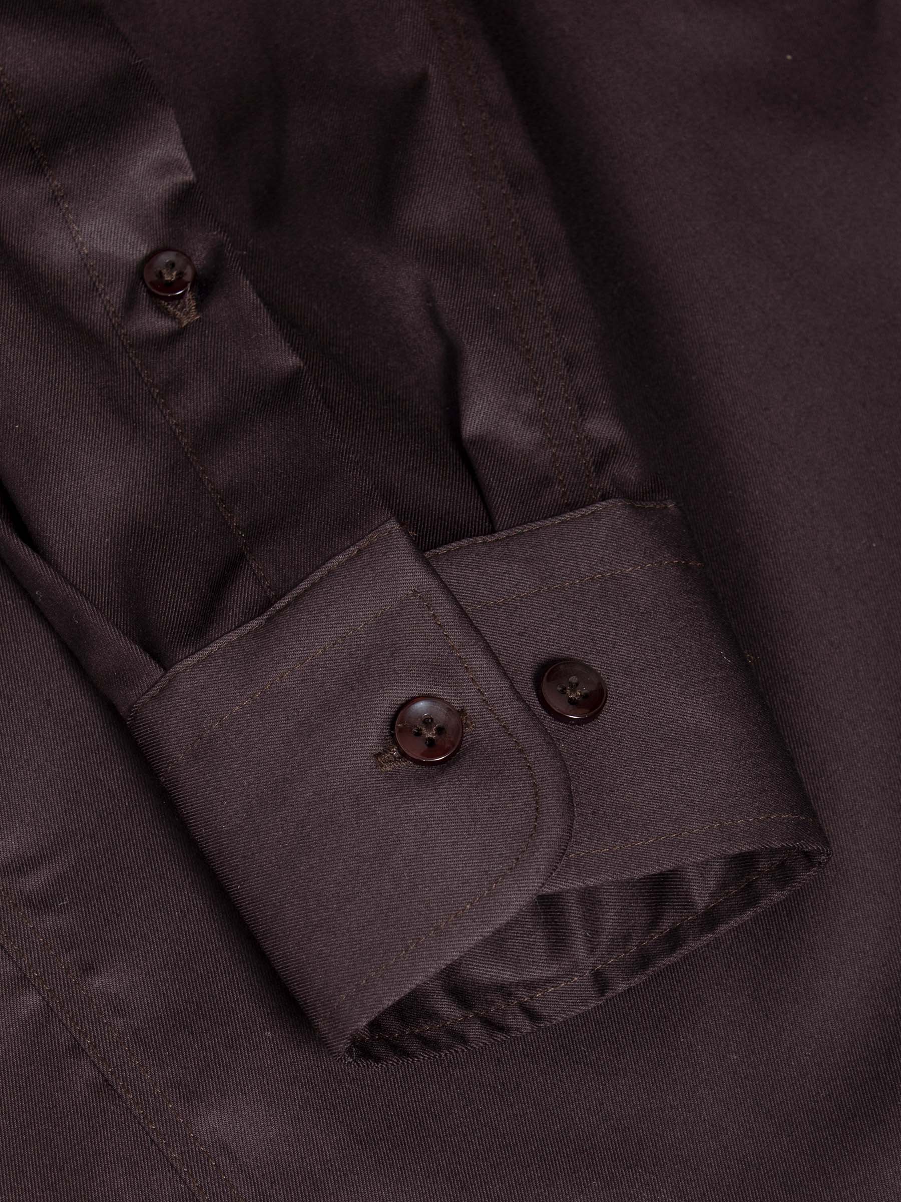 Close-up of brown men’s shirt cuff with button detail and stitching